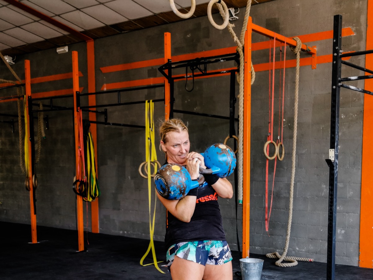 Personal trainer in Kalamata — Anna holding two competition kettlebells in rack position